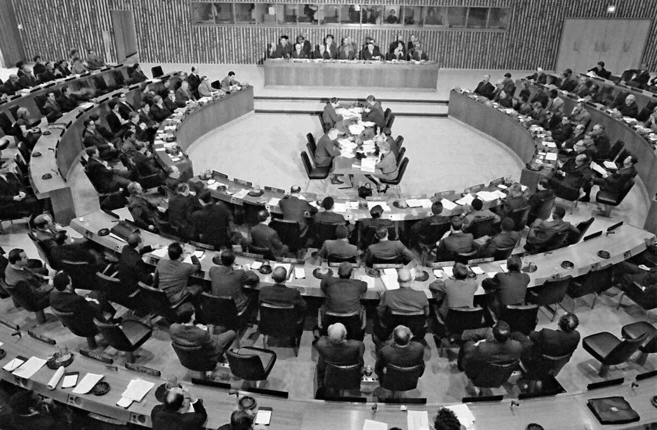 Primera reunión del Consejo de Administración del PNUD en Nueva York, 1966. Los delegados están sentados en una sala de conferencias semicircular, debatiendo o escuchando atentamente.