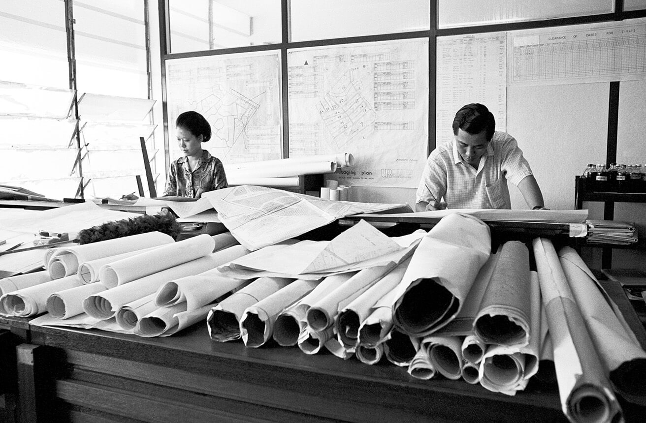 Dibujantes técnicos trabajando en planos de arquitectura o de planificación urbana para el Programa de Renovación Urbana de Singapur.